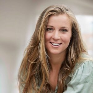 Portrait Person weiblich gelesen, weiß, blonde lange Haare lächelnd