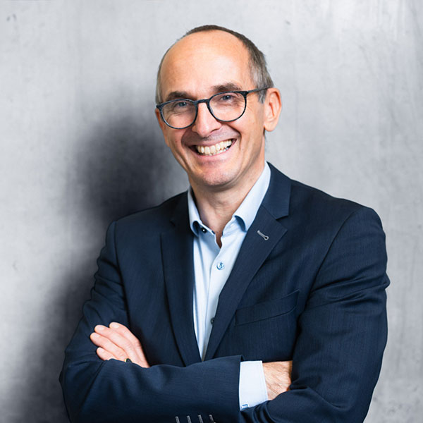 Person männlich gelesen, weiß, Portrait. Brille, graue Haare, lacht